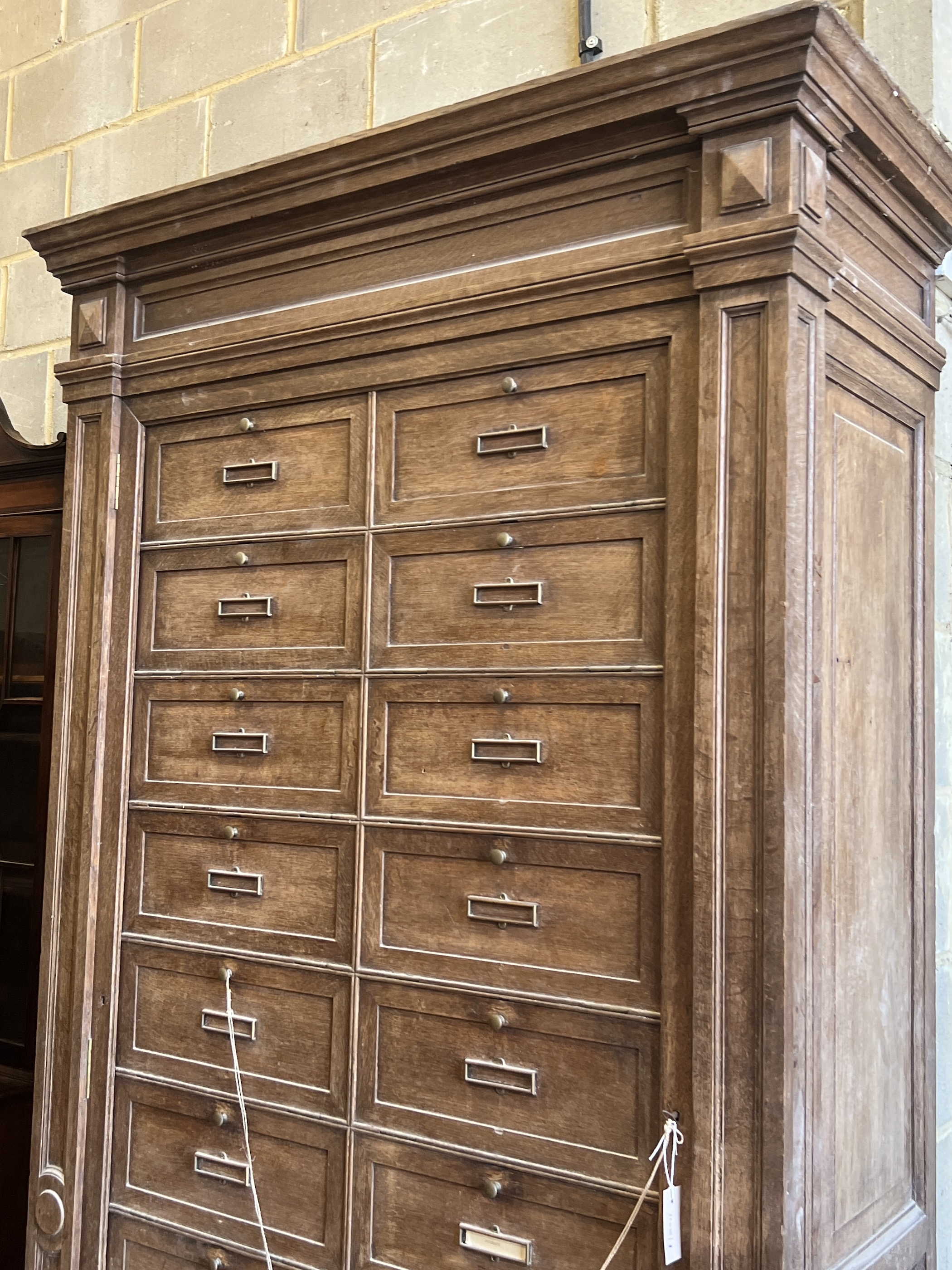 An early 20th century French oak notaries cabinet with 20 fall front compartments, width 125cm, depth 60cm, height 240cm
